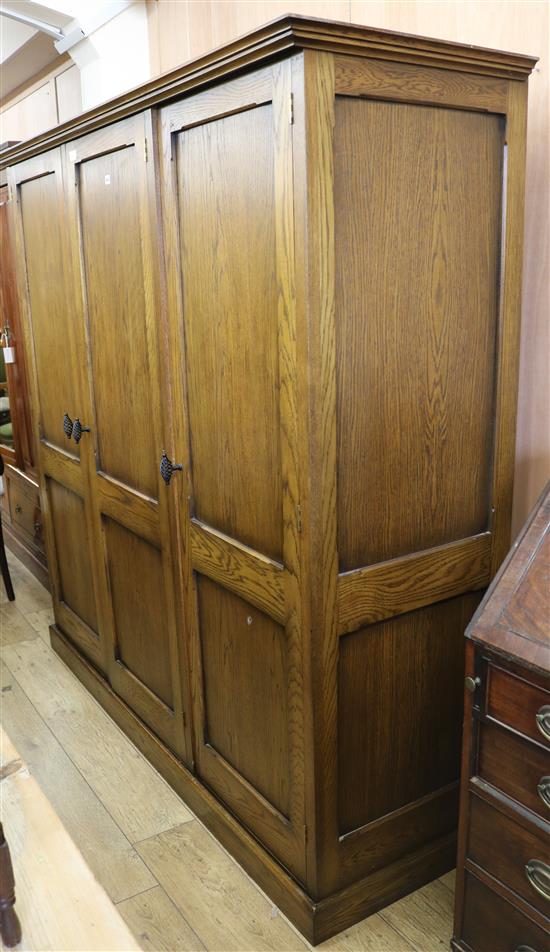 A modern panelled oak three door hanging wardrobe, H.187cm